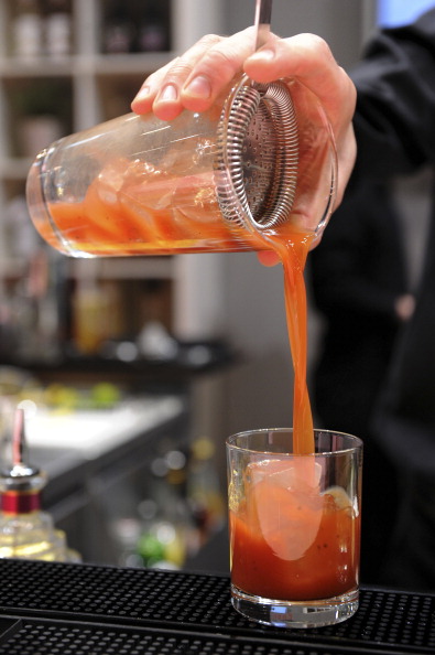 A barman pours a cocktail in a glass at 