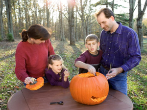Family Celebrates Halloween By Carving APumpkin 
