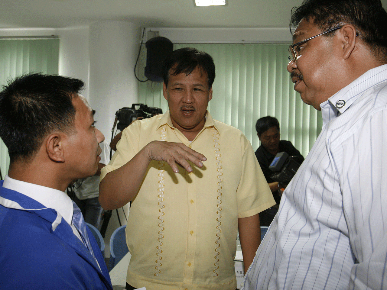 Interior and local government secretary Jesse Robredo, center,  gestures as he questions Radio Mindanao Network  anchor Michael Rogas, left,  at the Department of Justice in Manila on September 7, 2010.  