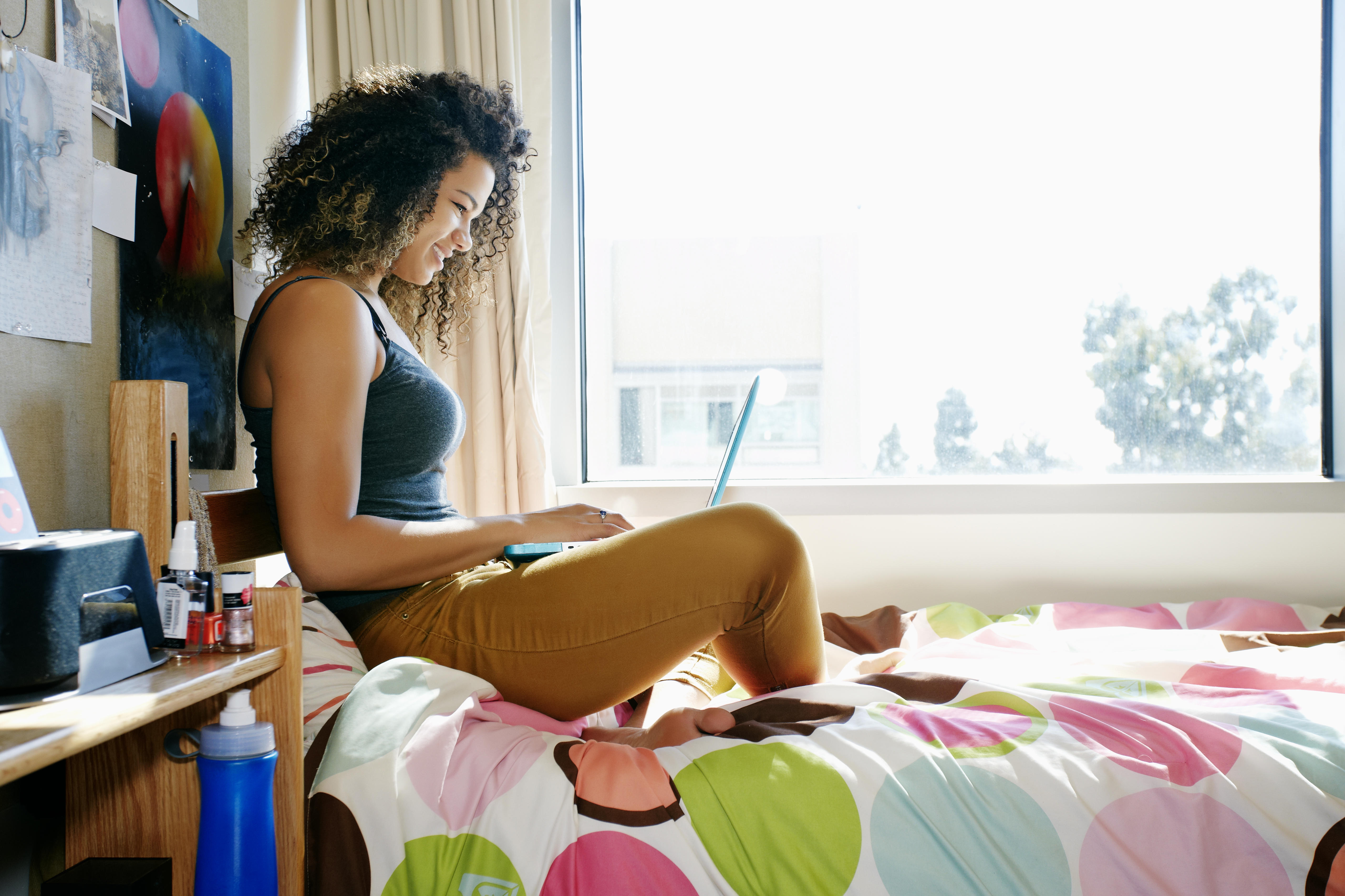 college student using laptop in dorm 