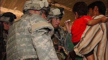 U.S. Army doctor examines Iraqi child in Baghdad 5-28-06 