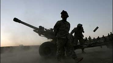 A U.S. soldier throws an artillery shell, Musa Qala, Afghanistan. 