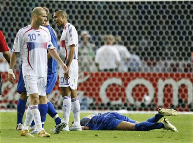 France's Zineidine Zidane walks past Marco Materazzi, on the ground, after he received a red card 