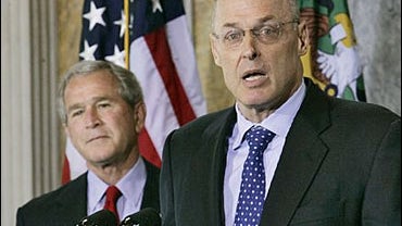 President Bush, left, stands behind Treasury Secretary Henry Paulson 