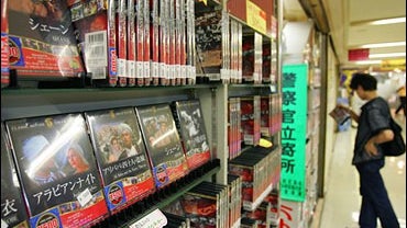 A shopper checks a DVD where a collection of DVD movie classics sold at 500 yen each at a DVD/video shop in Tokyo 