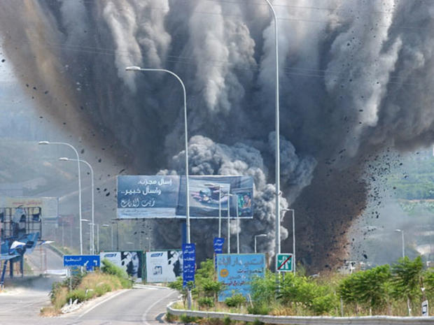 Smoke rises and debris fly from a bridge as it is targeted by an Israeli air raid 