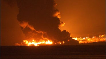 A fuel storage tank at a power station burns after it was set on fire when Israeli warplanes targeted it. 