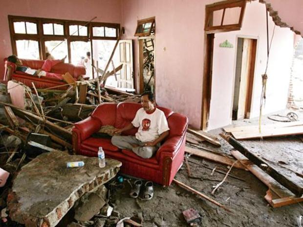 Indonesian man sits in the living room of a beachfront house destroyed by a tsunami 