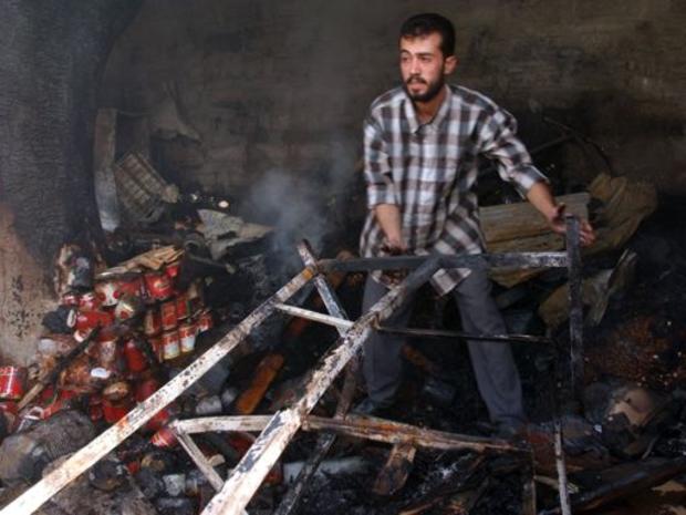 A shop owner tries to salvage anything of value from his shop destroyed in a bomb attack 