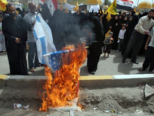 Iraqi's burn an American flag during a protest march denouncing Israel's Sunday attack in southern Lebanon, Monday, July 31, 2006 