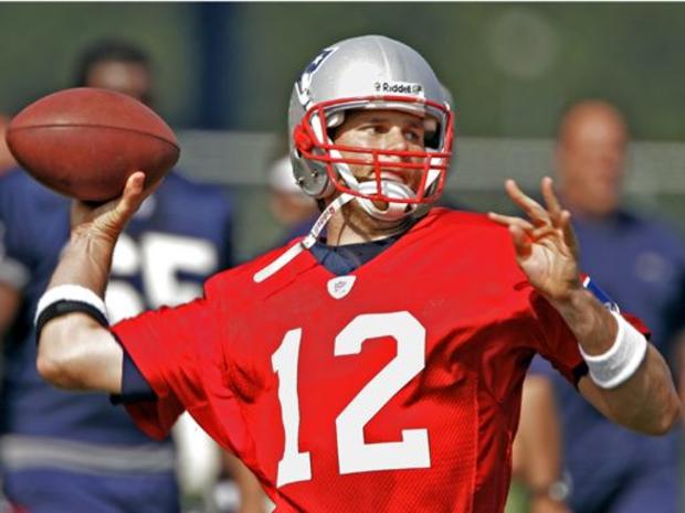 New England Patriots quarterback Tom Brady (12) drops back to pass as the team scrimmages during the afternoon session of the team's summer football camp in Foxborough, Mass. 