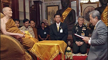 New Thai Interim Prime Minister Surayud Chulanont, right, reads before Buddhist monk His Holiness Somdet Phra Nyanasamvara Somdet Phra Sangharaja at Wat Bowonniwet temple in Bangkok, Thailand, Monday, Oct. 2, 2006. 