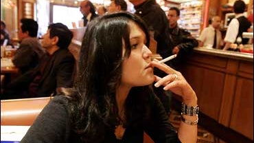A student smokes a cigarette in a cafe in Paris, Tuesday Oct. 3, 2006 in Paris. 