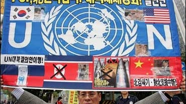A protester in front of the government complex building in Seoul, South Korea, Oct. 17, 2006, holds a poster denouncing North Korea's nuclear weapons test. 