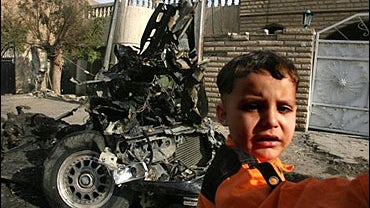Iraqi boy cries as he passes by the spot where a suicide car bomber slammed into wedding party in Baghdad, Iraq, Wednesday Nov. 1, 2006. 