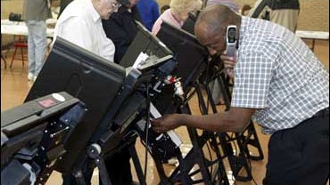 An election supervisor works on one of the touchscreen ballot machines at the Jackson Park school Tuesday, Nov. 7, 2006 in University City, Mo. Two of the four touchscreen machines at the school were out of operation at the time. 