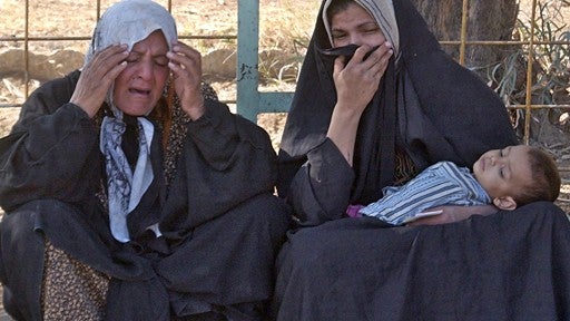 Iraqi women grieve over the death of their relative killed in sectarian violence, at the morgue yard in Baqouba 
