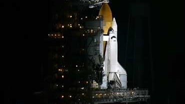Space shuttle awaits launch at night 