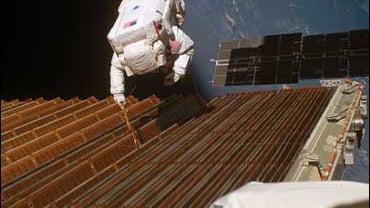 Astronaut works on solar array 