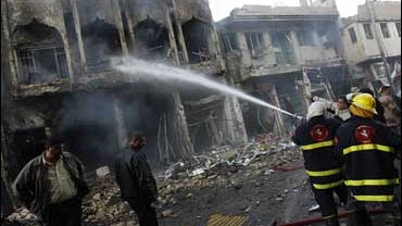 Fire fighters put out the flames at the scene of a triple car bombing in a Shiite neighbourhood of Al-Horreya district in Baghdad 30 December 2006. 