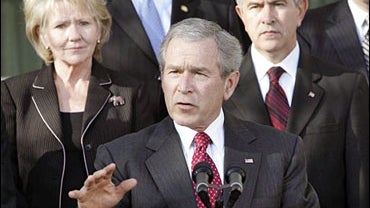 President Bush, center, accompanied by members of his Cabinet gestures while speaking in the Rose Garden of the White House in Washington, Wednesday, Jan. 3, 2007. 