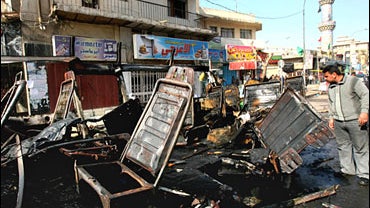 A man looks at a destroyed minibus in a predominantly Shiite district of Karrada in Baghdad, Iraq 