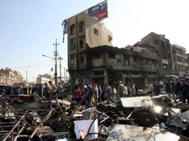 Iraqis gather at the scene of Sunday's twin car bomb attack in Baghdad, Iraq, Monday, Feb. 19, 2007. 