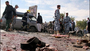 Scattered human remains lay on a street after a car bomb attack in Najaf, 160 kilometers (100 miles) south of Baghdad, Iraq, Wednesday, Feb. 21, 2007. 