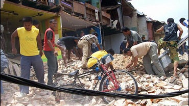 Rescue workers try to clear an area badly damaged in Payakumbuh, West Sumatra 