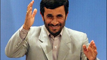 Iranian President Mahmoud Ahmadinejad waves to the media as he arrives at a press conference 