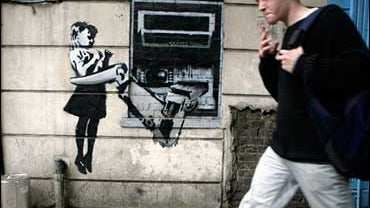 Banksy's spray painted depiction of a cash machine grabbing a child 