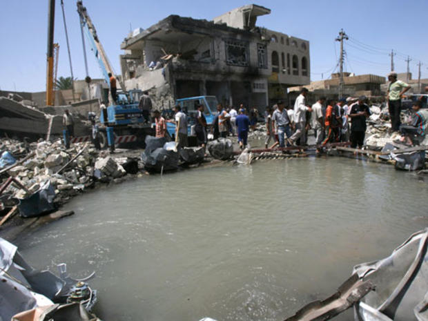 People gather around a bomb crater after a deadly blast occurred in the Shiite-dominated neighborhood of Amil, Baghdad, Iraq, on Tuesday, May 22, 2007. 