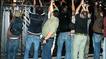 Photographers shoot over the gate at the home of Paris Hilton Thursday, June 7, 2007, in Los Angeles. 