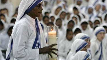 A Missionaries of Charity nun carries a lamp at a mass for Mother Teresa. 
