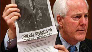 Sen. John Cornyn (R-TX) holds up a copy of an ad paid for by MoveOn.org during a hearing of the Senate Armed Services Committee, 9/11/07 