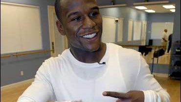 Floyd Mayweather Jr. poses with a pair of shoes during practice for a television reality show "Dancing With The Stars" 