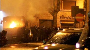 Policemen near burning police bus in Rome following clashes with soccer fans 