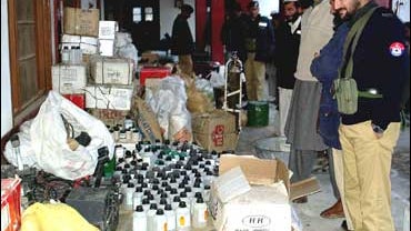 Pakistani police stand beside confiscated explosives and other material at police headquarters in Mingora 
