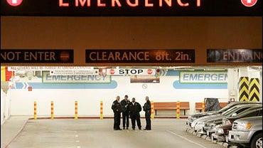 Security guards stand outside of the ambulance entrance to the at the UCLA Medical Center emergency room in Los Angeles 