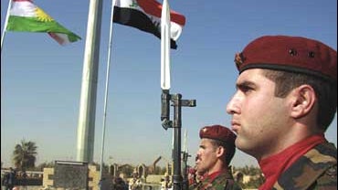 The new Iraqi flag, right, is raised in the courtyard of the Kurdish parliament in Irbil, Iraq 