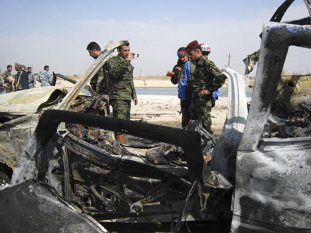Iraqi soldiers inspect a car bomb wreck at a checkpoint in Fallujah, Iraq, Monday, Feb. 11, 2008. 