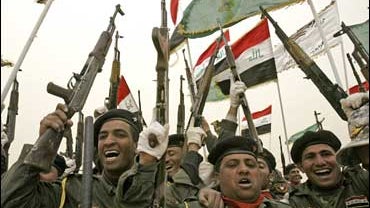 Iraqi police officers cheer during a graduation ceremony north of Najaf 