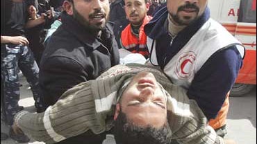 Palestinian medics carry a man wounded during an Israeli army operation in the northern Gaza Strip, into hospital in Beit Lahiya 