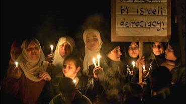 Palestinians attend a candlelight rally against Israeli sanctions in Gaza City 