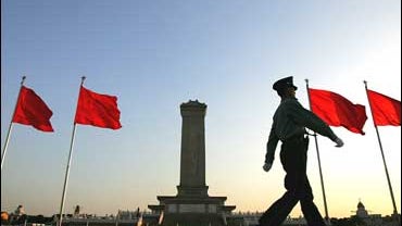 A security guard marches past flags decorating Beijing's Tiananmen Square 