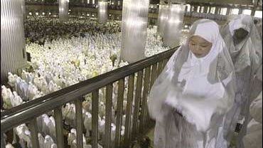 Muslim women perform a morning prayer marking the start of the Islamic feast of Eid al-Fitr at Istiqlal mosque in Jakarta 