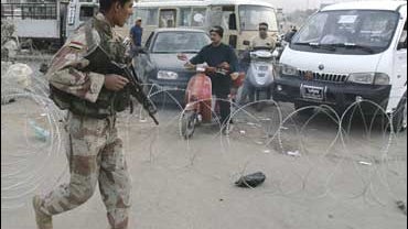 Iraqi Army's soldier removes razor wire as he lets cars out of the Shiite enclave of Sadr City 