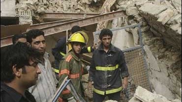 Fire fighters and residents search through the rubble of a destroyed house in the Shiite stronghold of Sadr City 