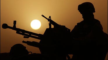 The sun sets as an Iraqi Army soldier secures a road in Amarah, 320 kilometers (200 miles) southeast of Baghdad, Iraq on Monday, June 16, 2008. While violence continues in Baghdad and north of the capital, Iraqi troops moved into place ahead of a new oper 