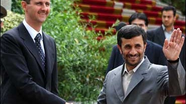 Iranian President Mahmoud Ahmadinejad, right, shakes hands with Syria's President Bashar Assad 